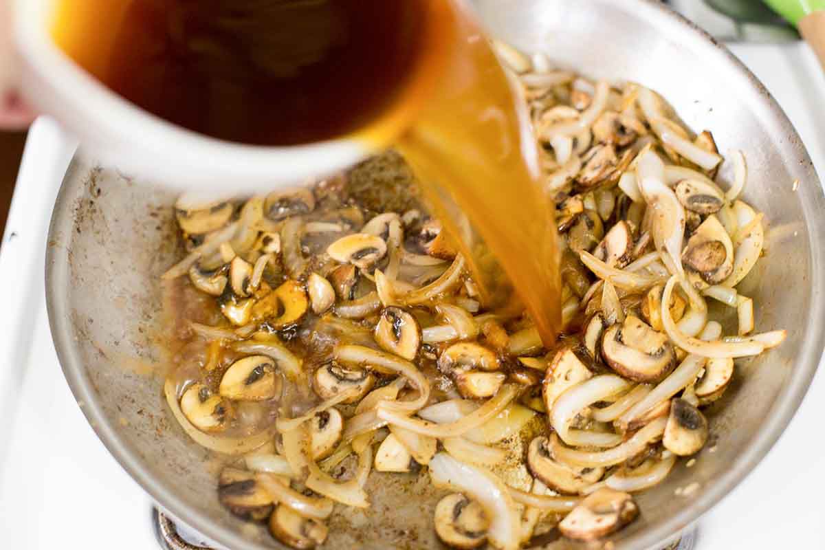 Add broth to the pan to make the best salisbury steak gravy