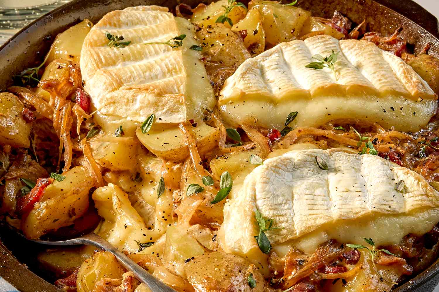 Tartiflette dish with melted cheese on top sauted potatoes and bacon