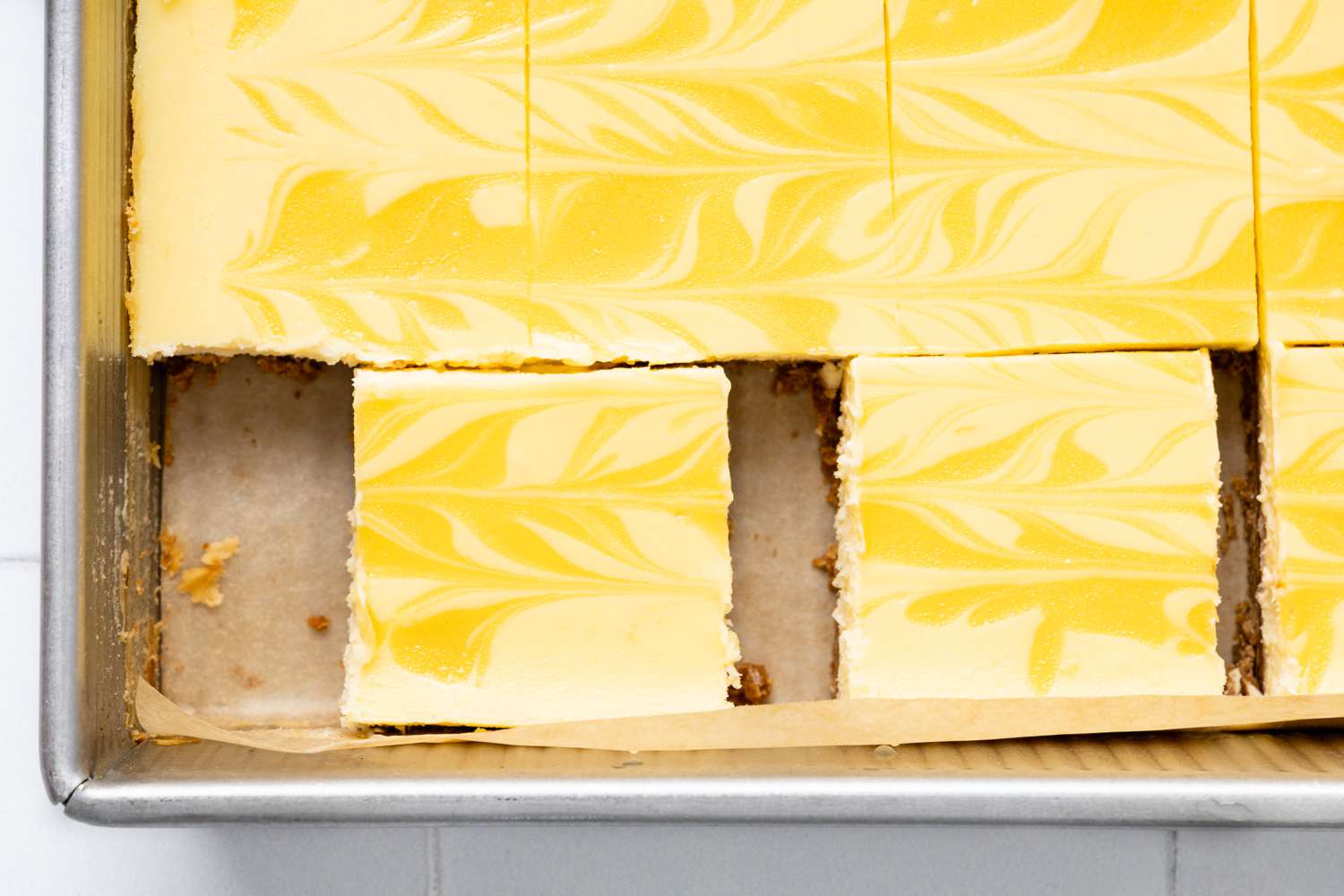 Lemon Cheesecake Bars in a Parchment Paper Lined Baking Sheet 