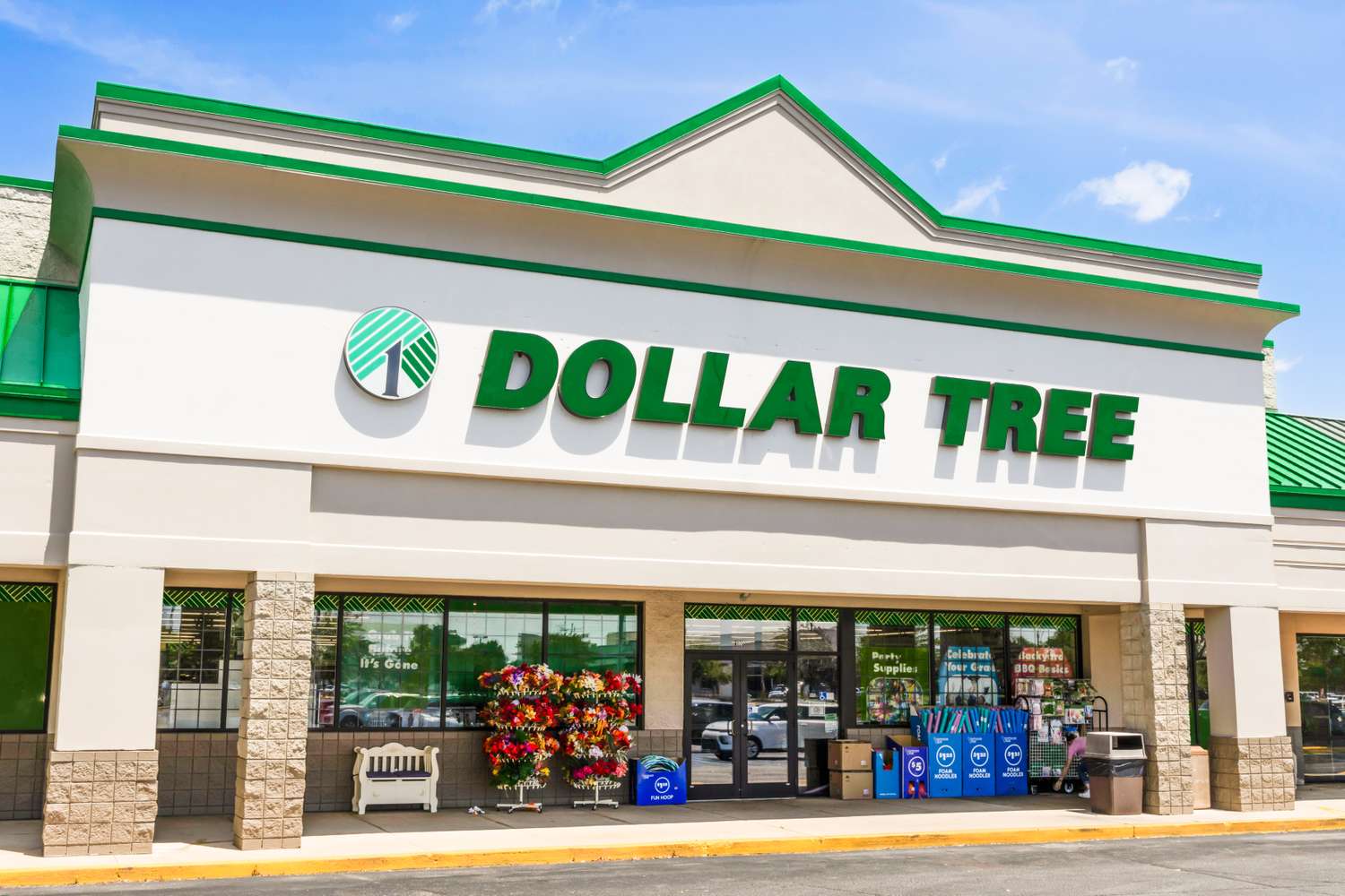 Exterior view of a Dollar Tree storefront with several items displayed at the entrance