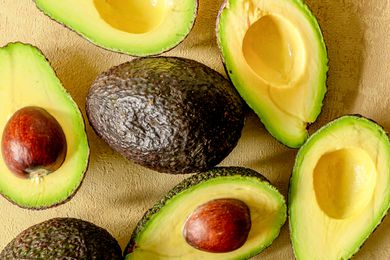 An assortment of avocados halved, some with pits and some without