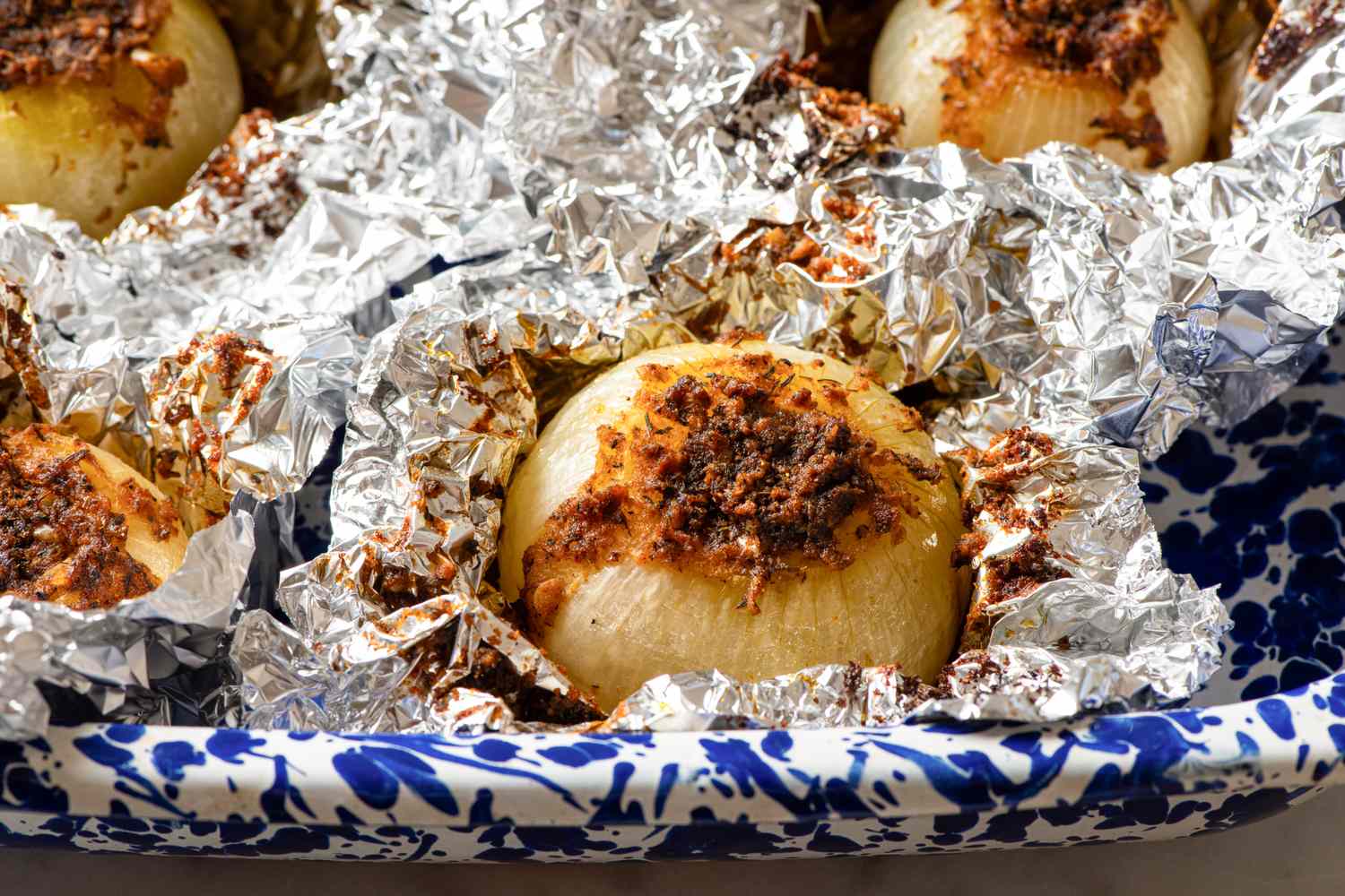 Baked onions wrapped in foil in a baking dish