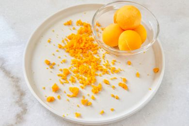 Grated egg yolks beside intact yolks in a bowl on a plate