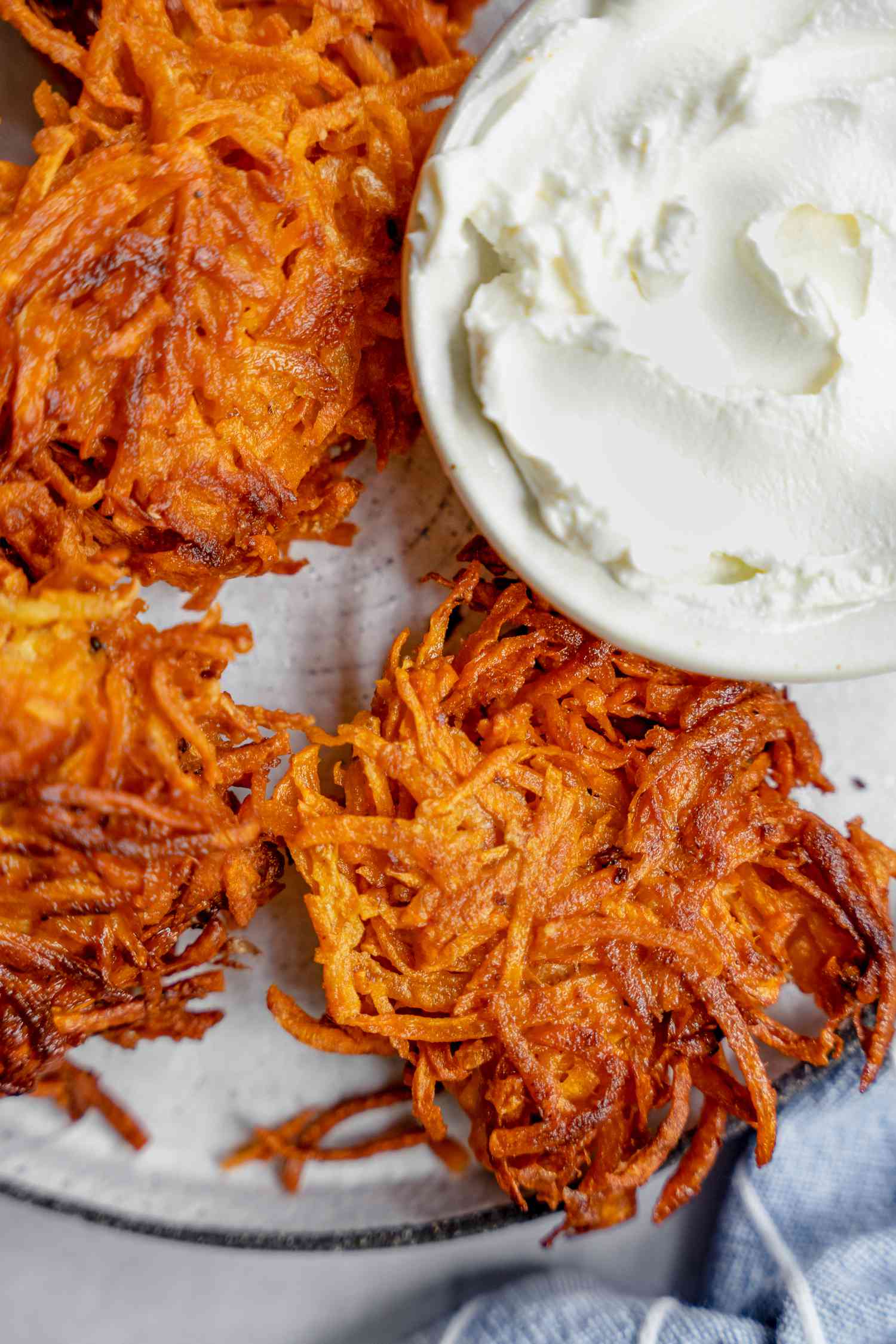 Plate of Sweet Potato Latkes Served with a Small Bowl of Sour Cream