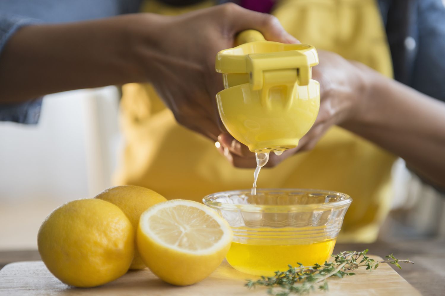 A lemon being squeezed in a lemon juicer