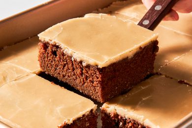 Dr. Pepper cake cut into squares with one square lifted using a spatula