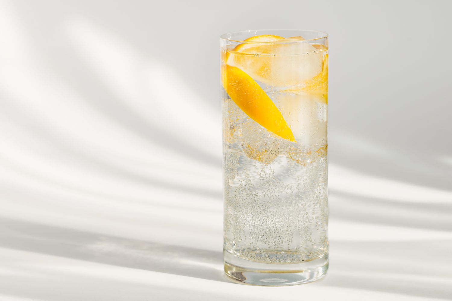 A glass of sparkling water with lemons. 