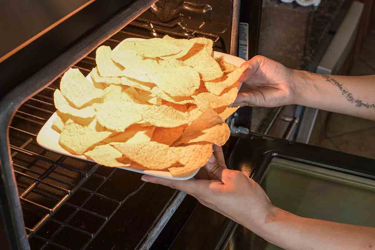 Tortilla chips on a platter being placed in a oven