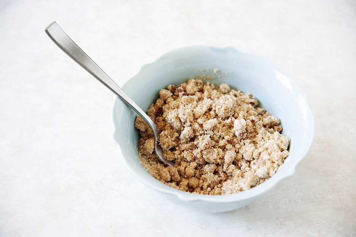 A blue bowl with crumble topping for a homemade Dutch Apple Pie