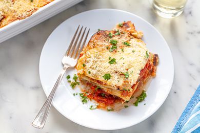 Vegetable moussaka on white plate with fork