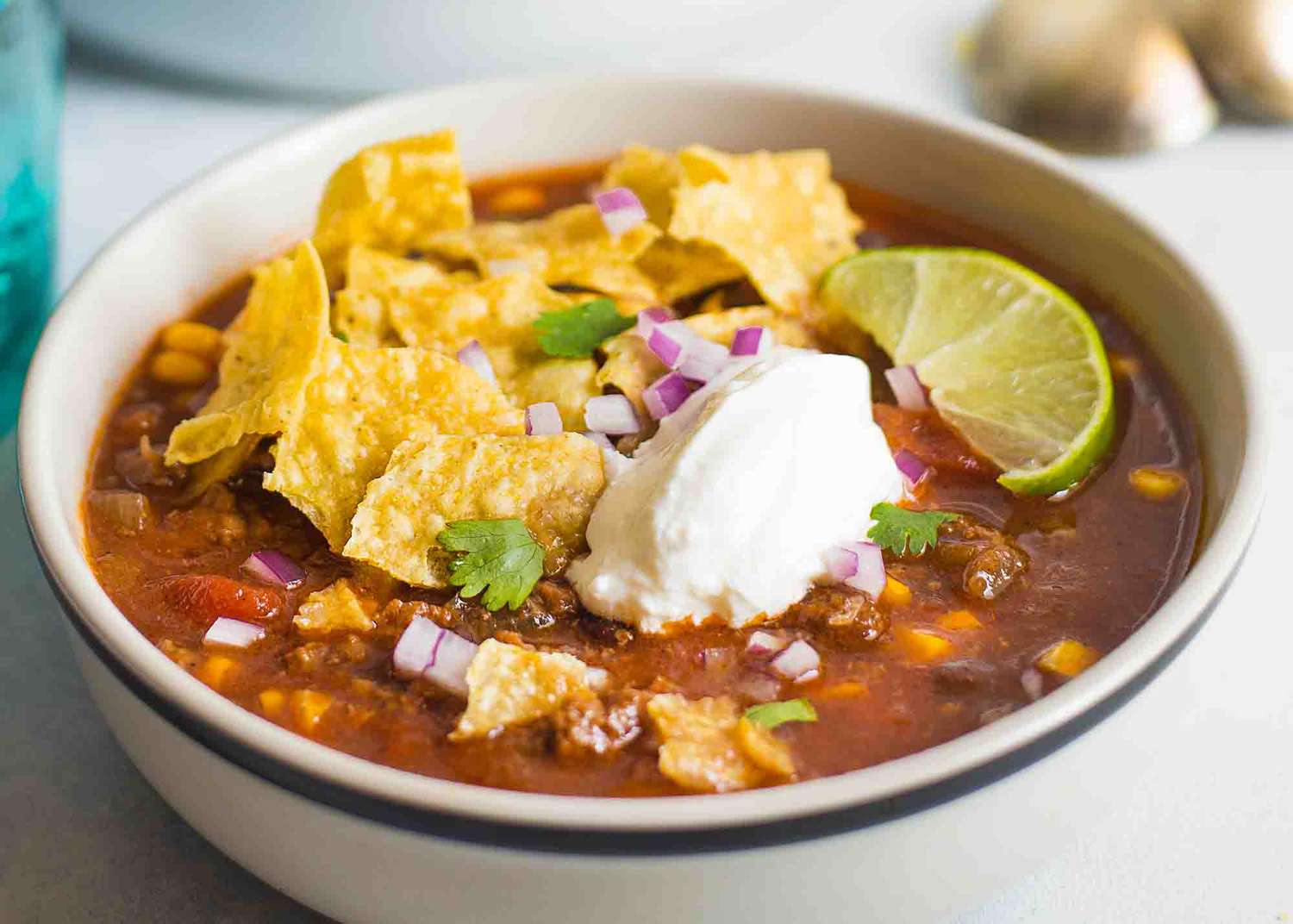 A bowl of crockpot Taco Soup topped with sour cream and chips