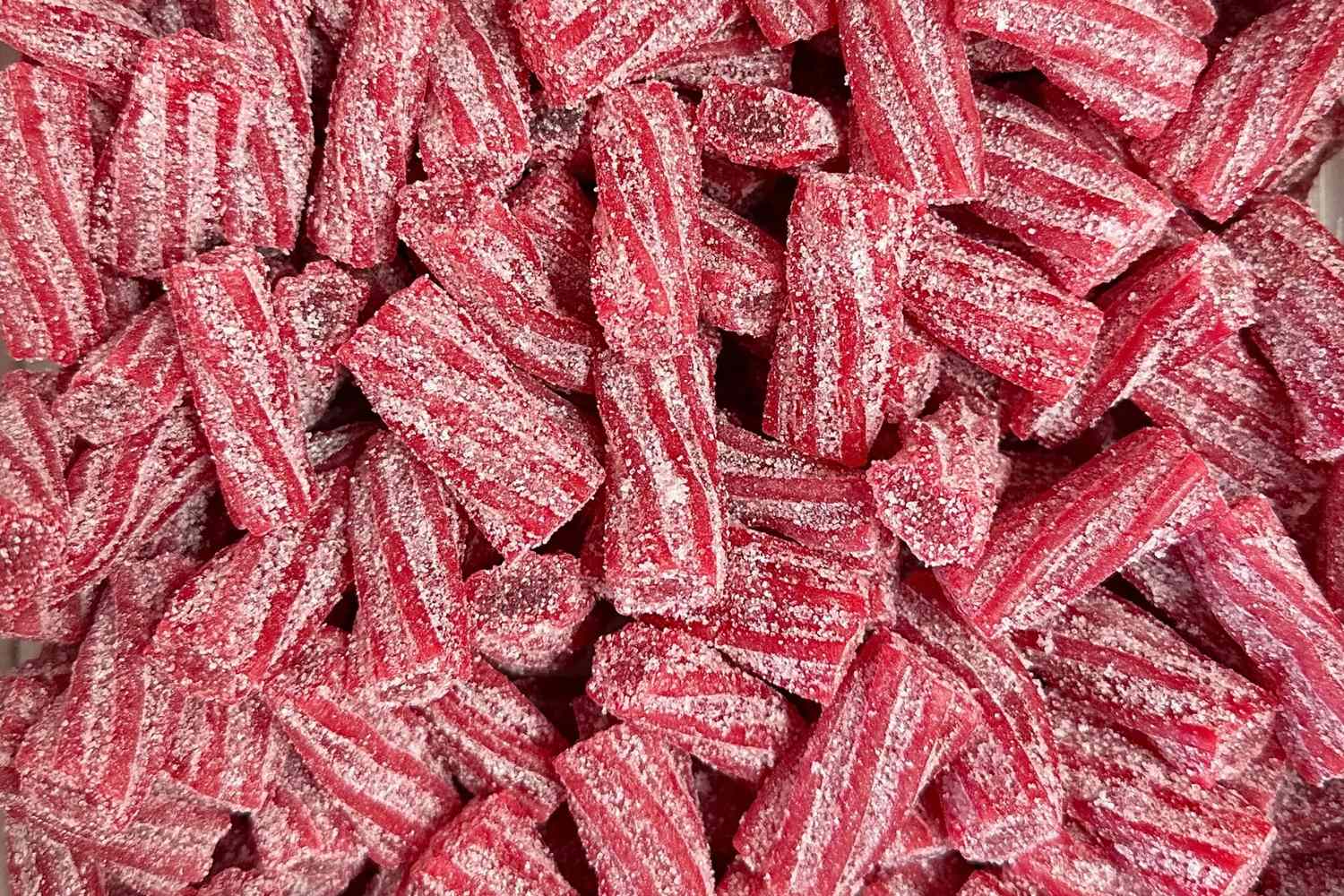 A pile of striped sugarcoated red candy pieces