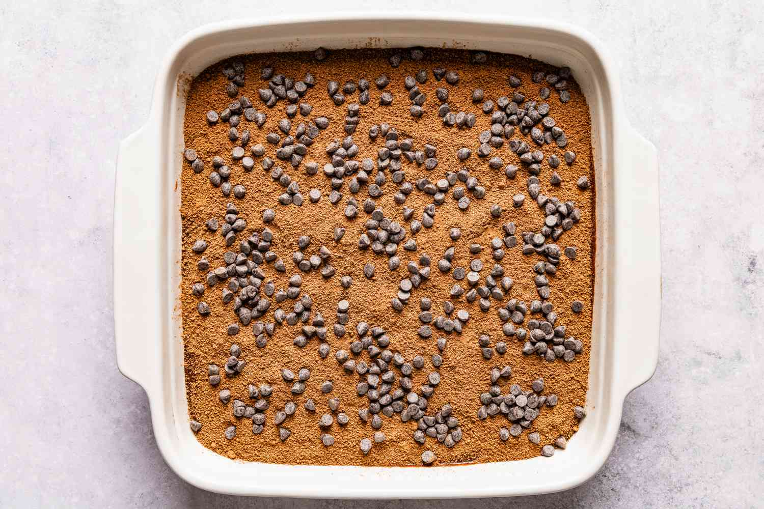 second layer of chocolate pudding cake batter topped with cocoa powder and chocolate chips