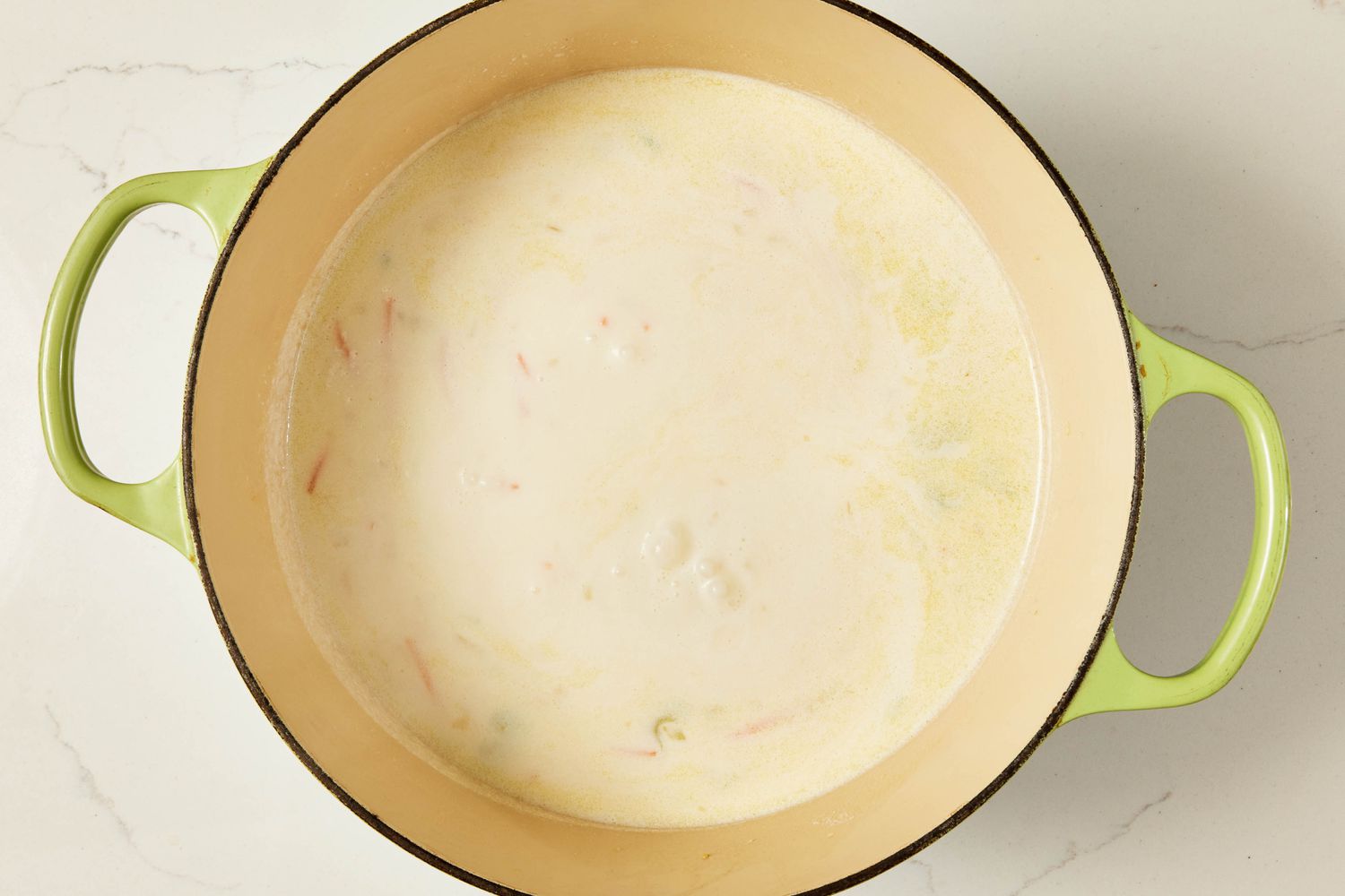 Half-and-half and chicken broth added to Dutch oven for copycat Olive Garden chicken and gnocchi soup recipe