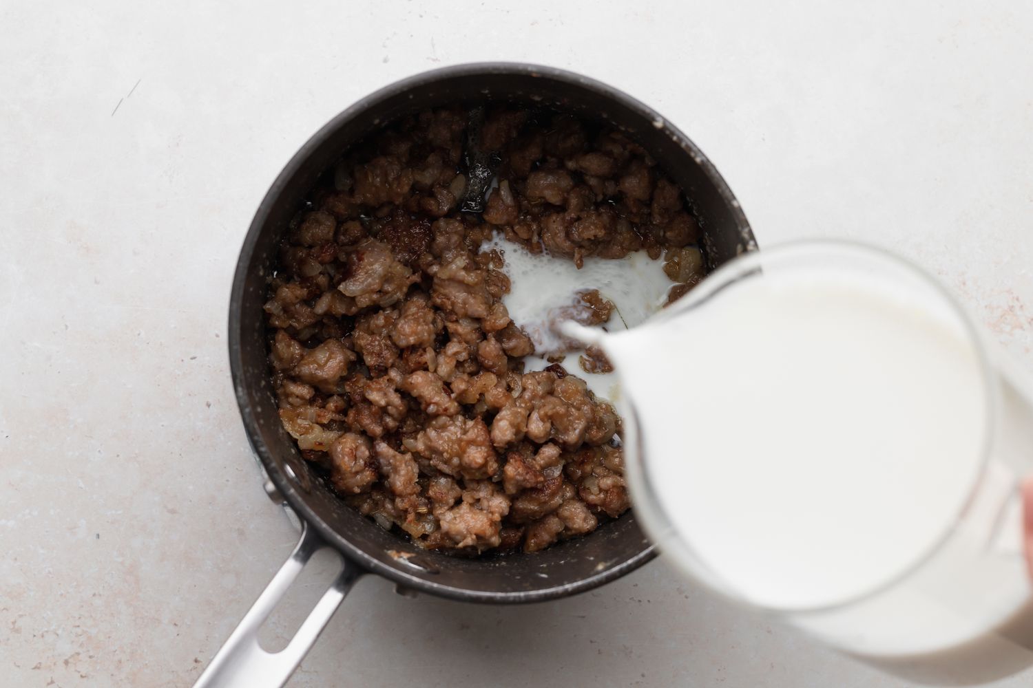 Adding milk to sausage mixture for homemade biscuits and gravy