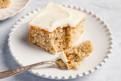 square slice of Feather Cake on a plate with a fork with a small bite portion on it