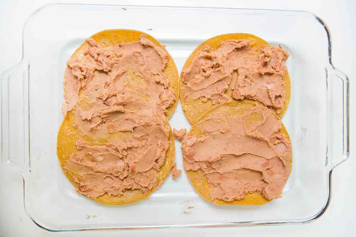 To make mexican lasagna add a layer of tortillas in the bottom of a 9x13 baking dish and spread with bean.