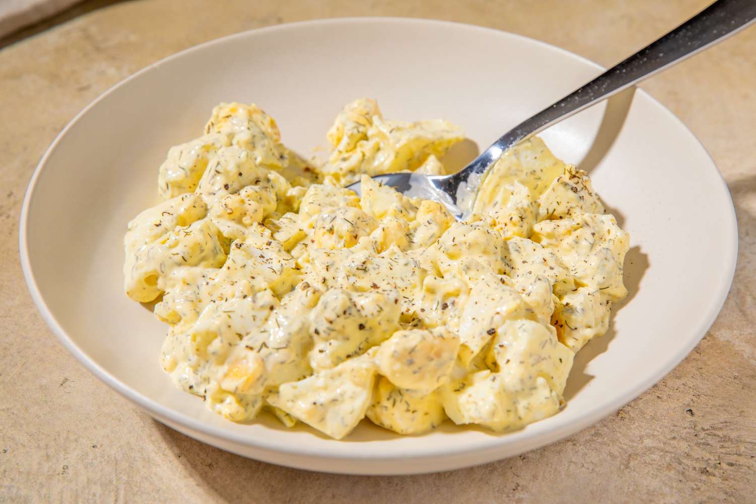 Bowl of egg salad with a spoon