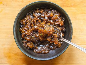 Balsamic onion jam in a grey bowl with a spoon.