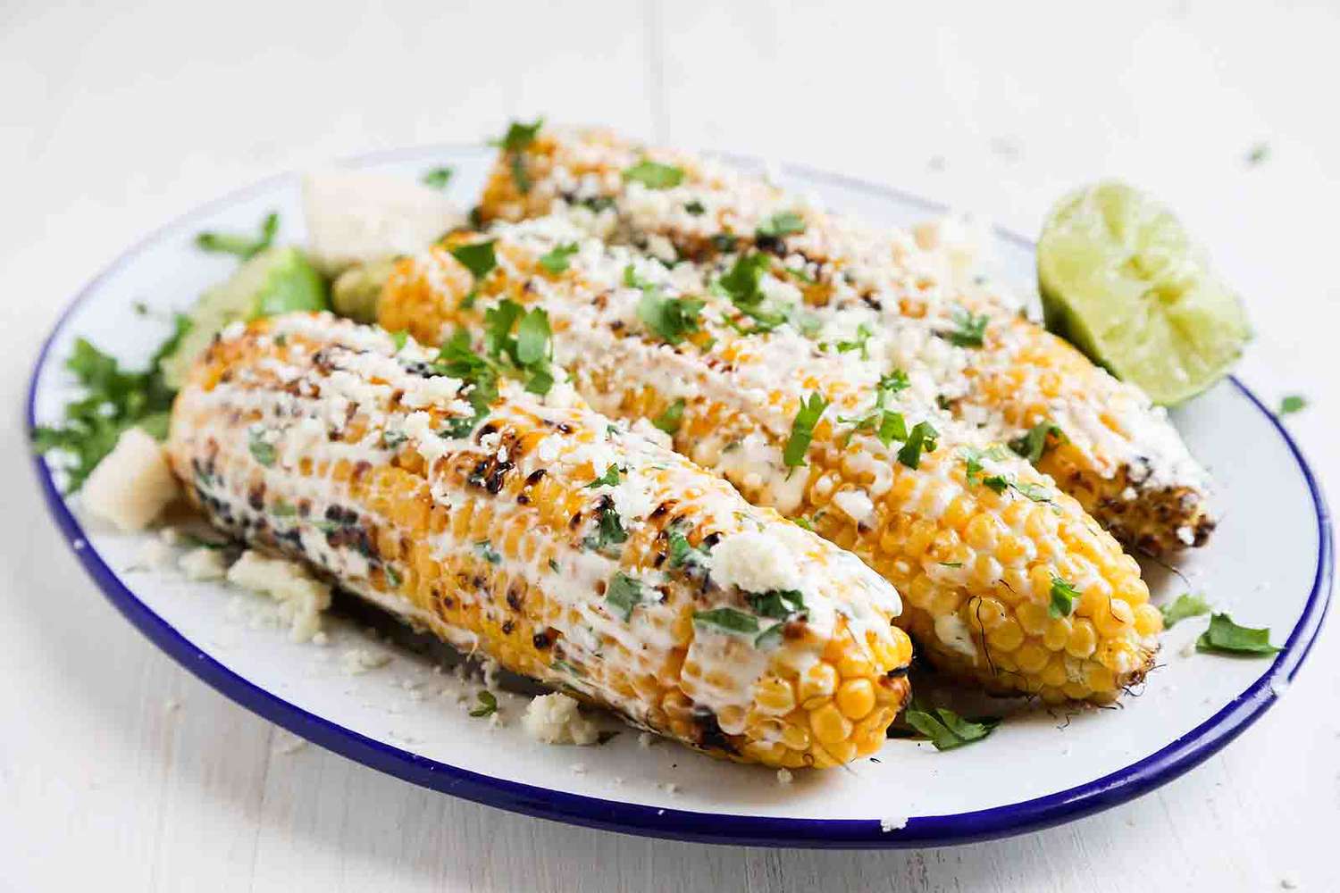 Mexican Street Corn topped with crema and cilantro on a plate