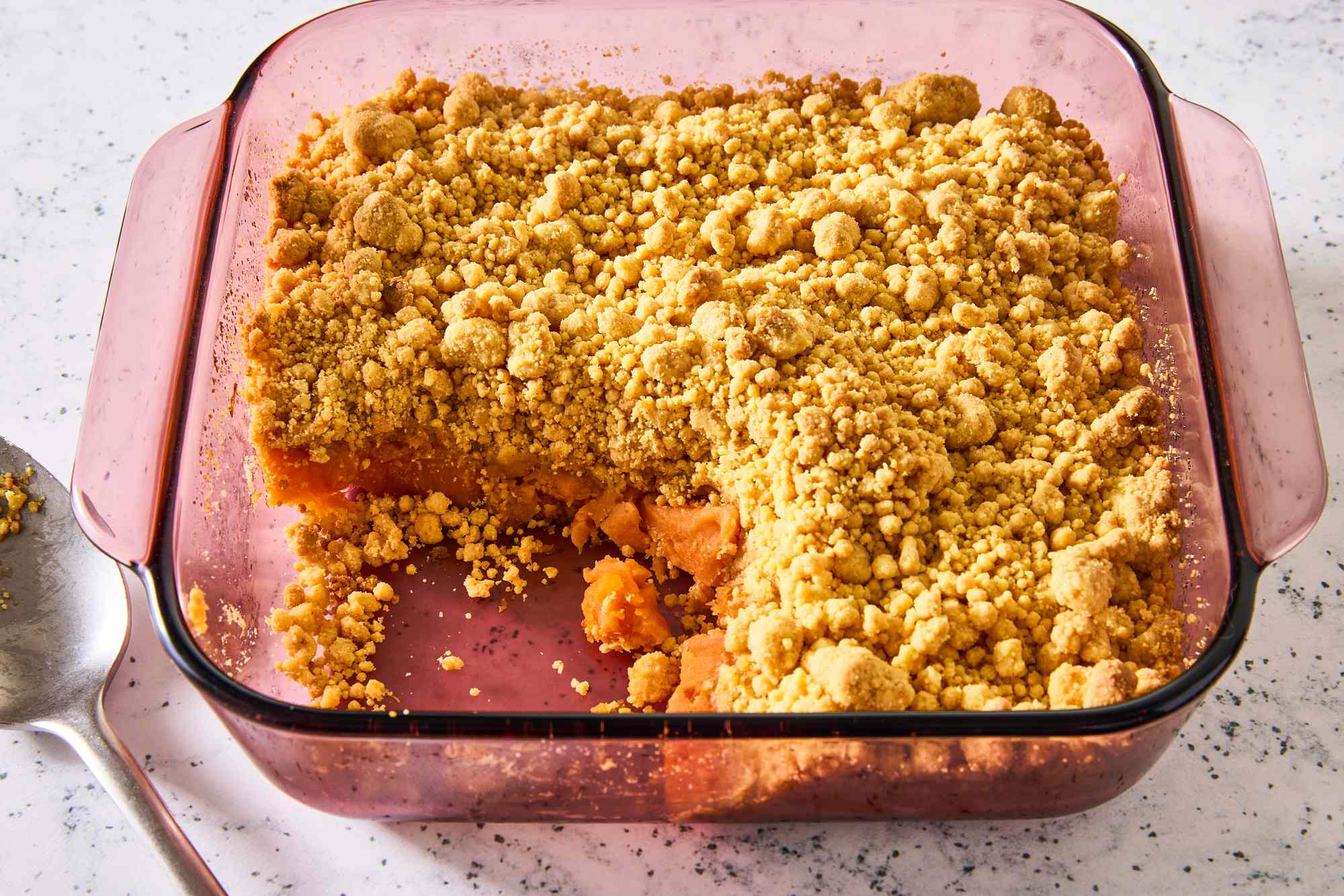 Sweet potato dump cake in a square baking dish with one serving taken out