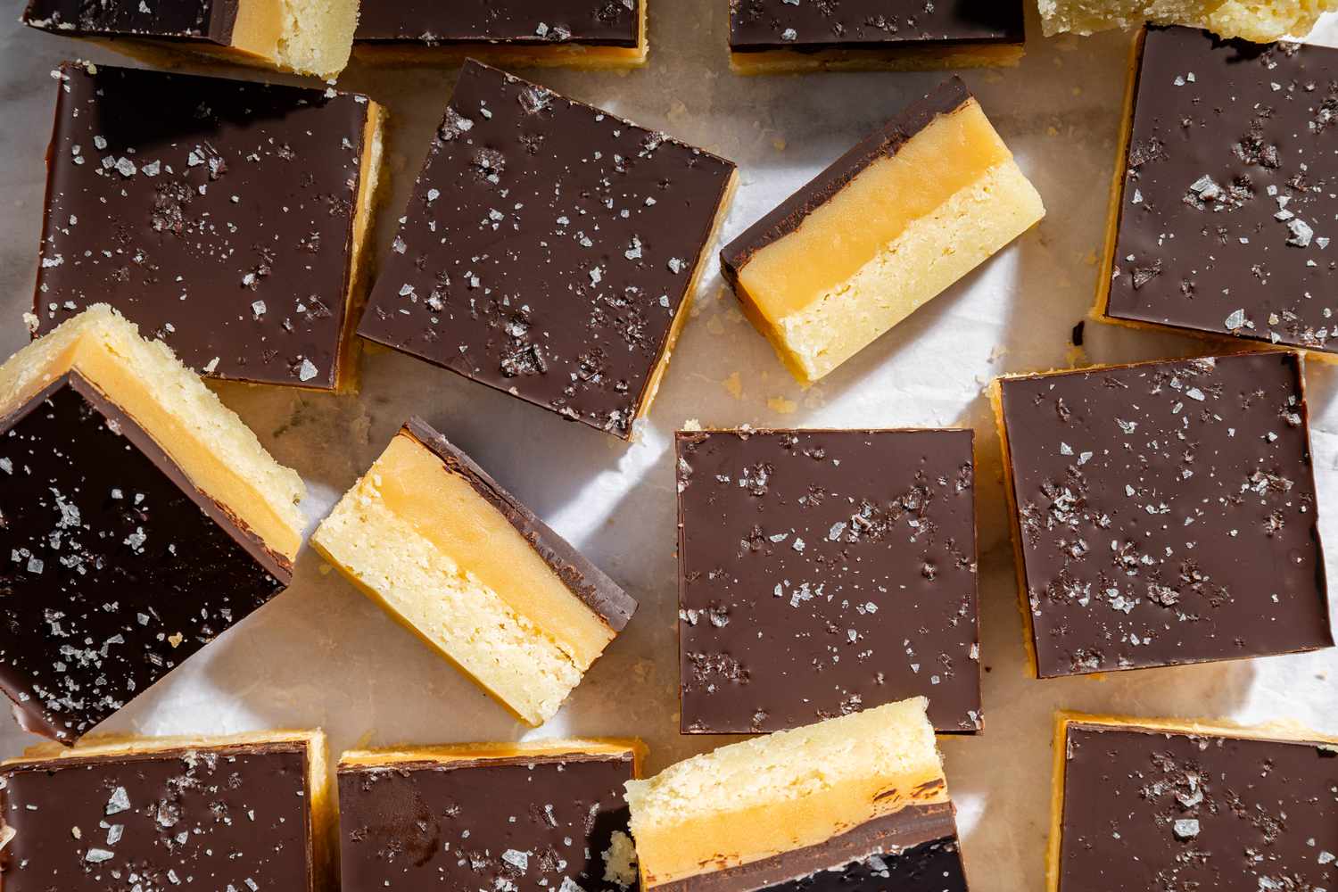 Overhead view of multiple Millionaire Shortbread bars on parchment paper