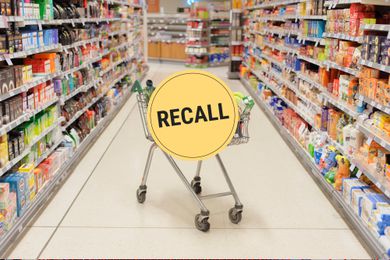A grocery store aisle with a full shopping cart in the middle and a "Recall" badge overlaid