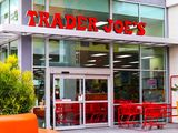 Entrance of a Trader Joes store with red shopping carts outside