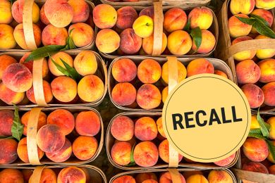 Several baskets of peaches with a recall label prominently displayed