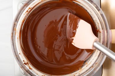 Overhead view of a glass bowl of melted chocolate.