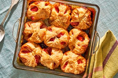 Peach dumplings in a glass pan on a blue tablecloth