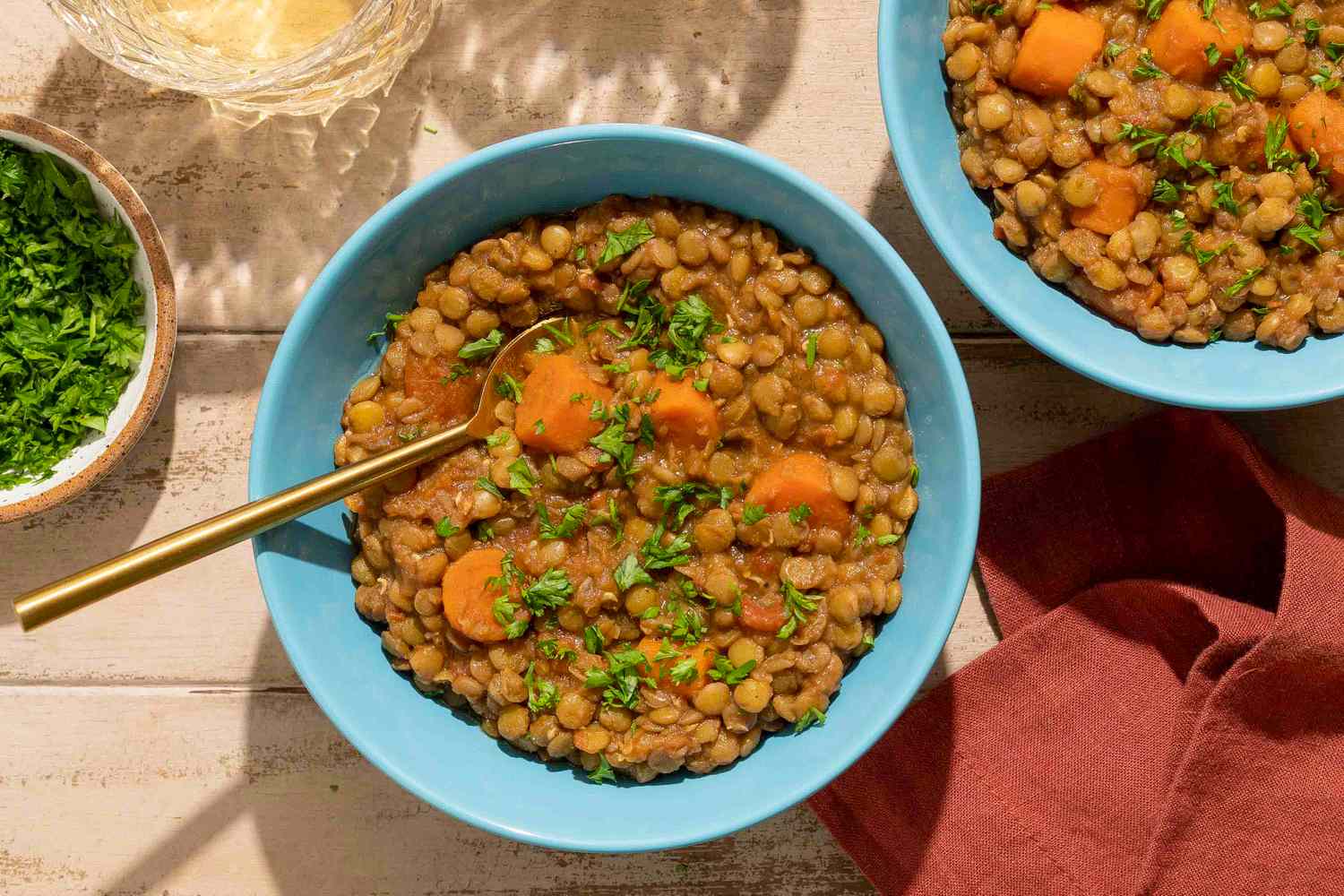 Bowls of spiced lentils with carrots garnished with herbs