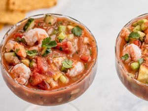 Overhead view of two stemmed glasses full of Mexican shrimp cocktail