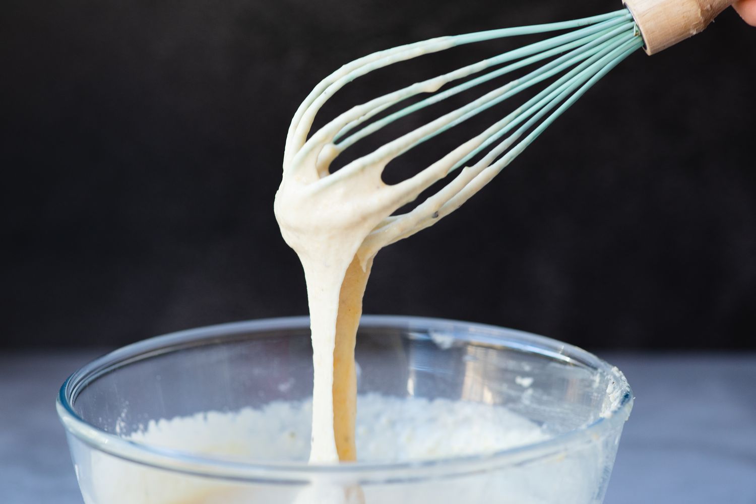 Whisking batter for a toad in the hole recipe.
