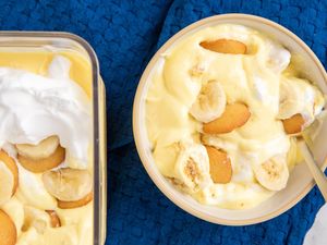 dish of Southern Banana Pudding topped with whipped cream next to a bowl of the pudding with a fork