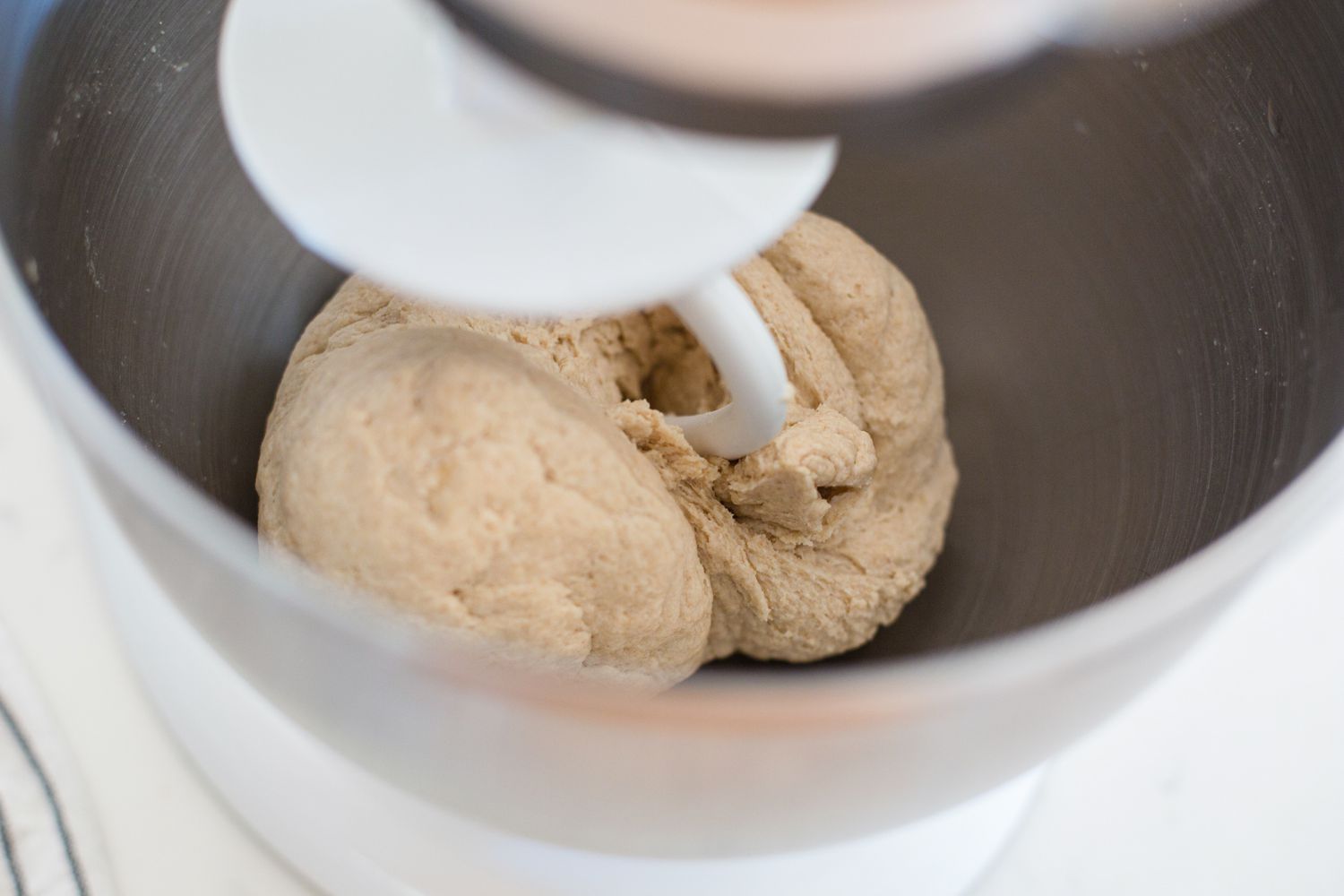 Kneading dough in a stand mixer to show how to make roti.
