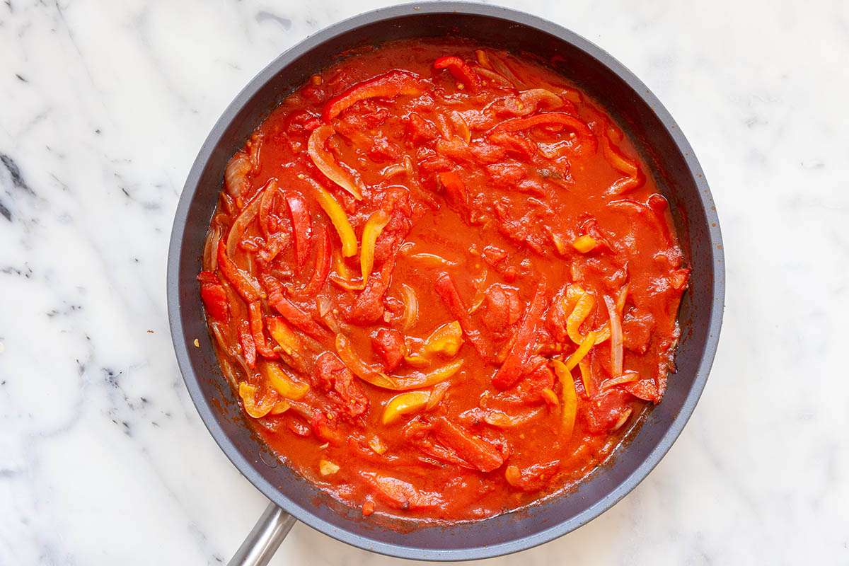 A skillet of sliced peppers in tomato sauce to make a Healthy Egg and Vegetable Skillet Breakfast.