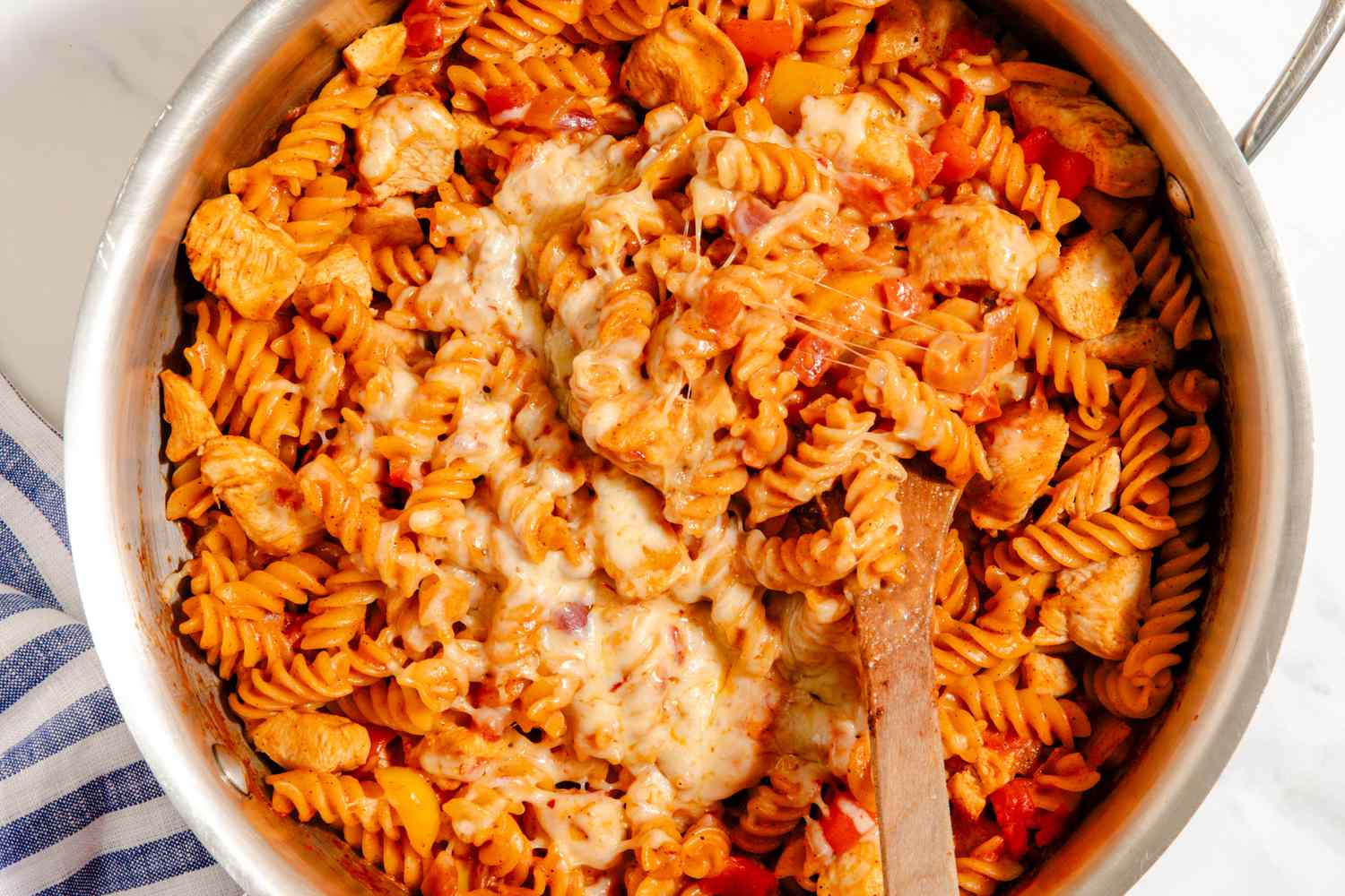 One-Pan Chicken Fajita Pasta in a pot with a wooden spoon