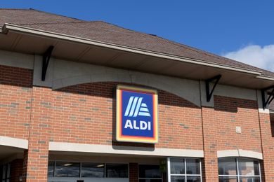 The exterior of an Aldi grocery store with its logo displayed on a brick and stucco facade