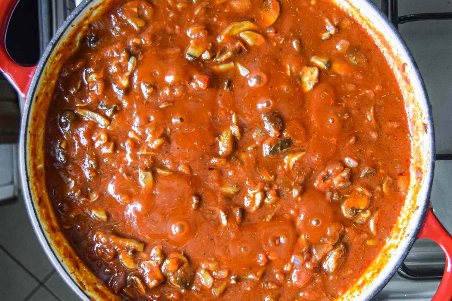 Tomato paste added to mushroom and onion mixture in a Dutch oven
