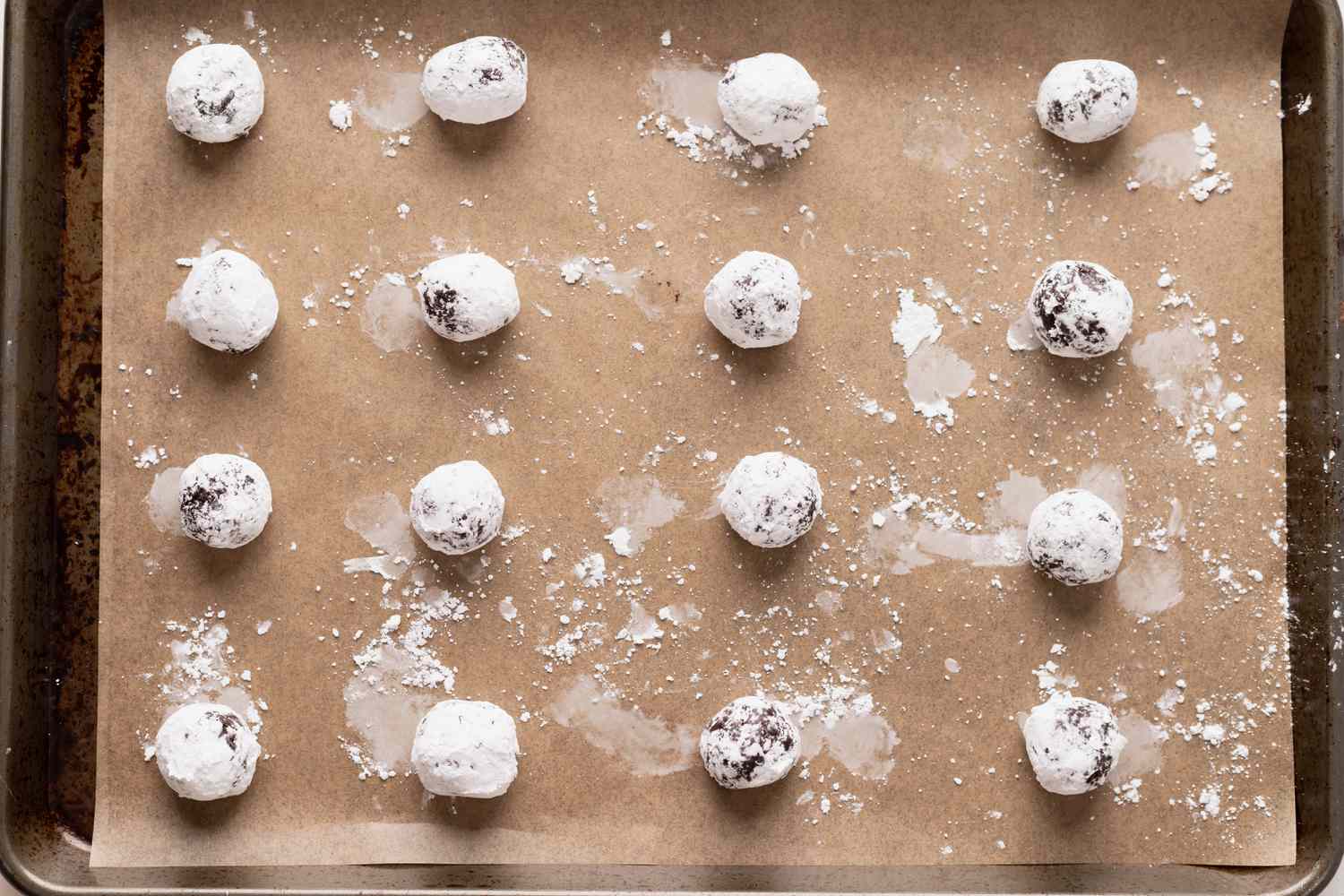 Baking sheet with chocolate crackle cookies ready to be baked.