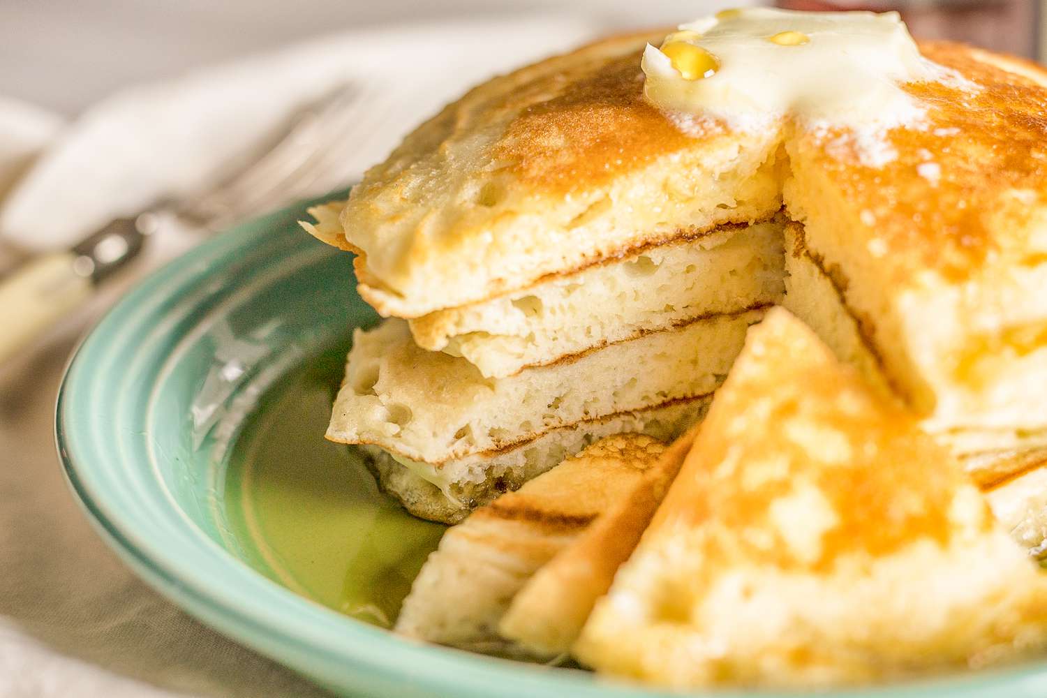 A stack of fluffy pancakes cut so that the inside layers are visible