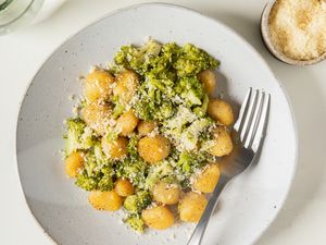 Gnocchi with broccoli and cheese on a plate with a fork