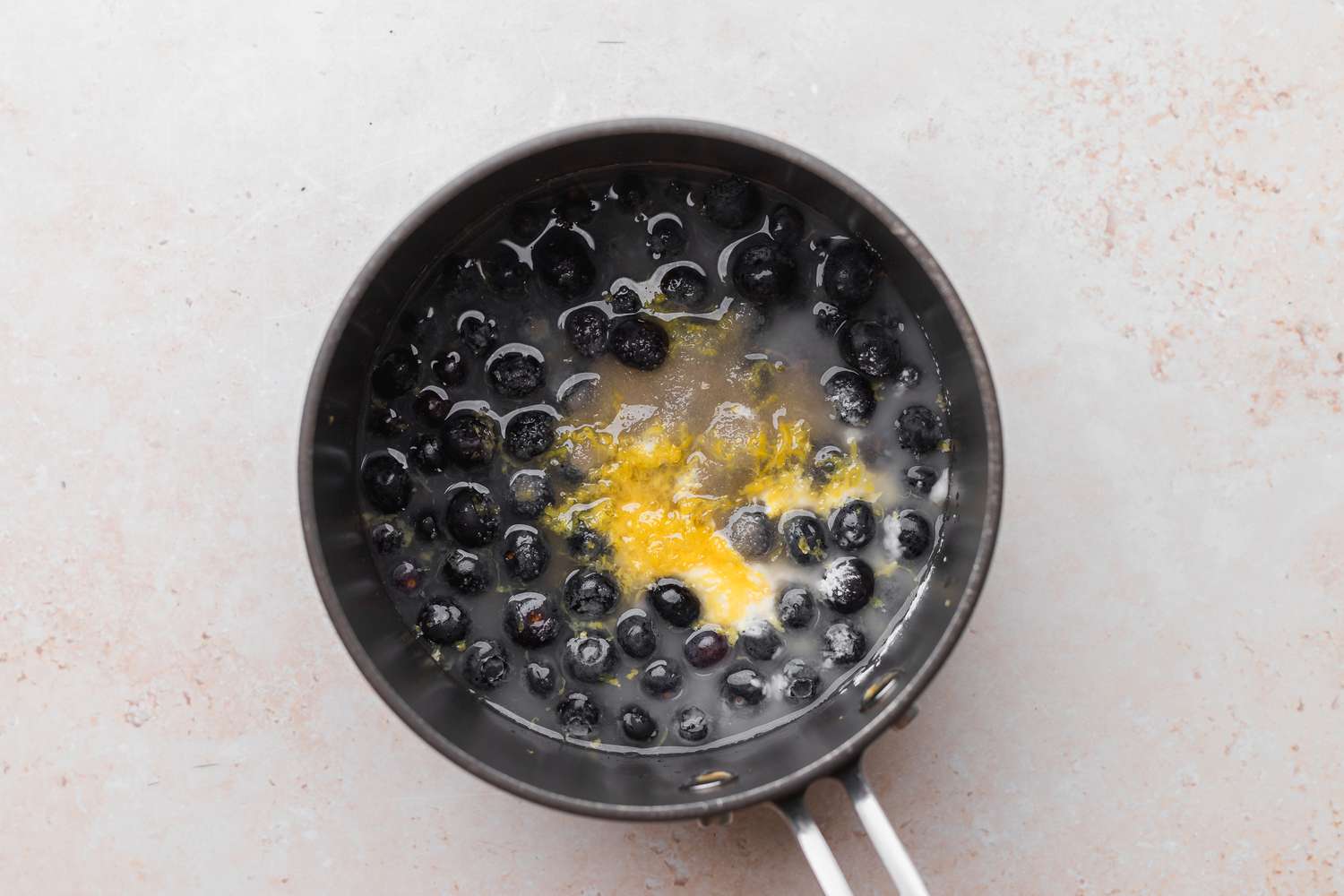 Blueberries, sugar, lemon and water in saucepan.