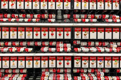 Shelving stocked with Campbells canned soups in various flavors