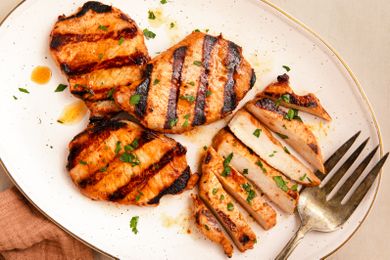 Grilled pork chops served on a plate with garnish and a fork