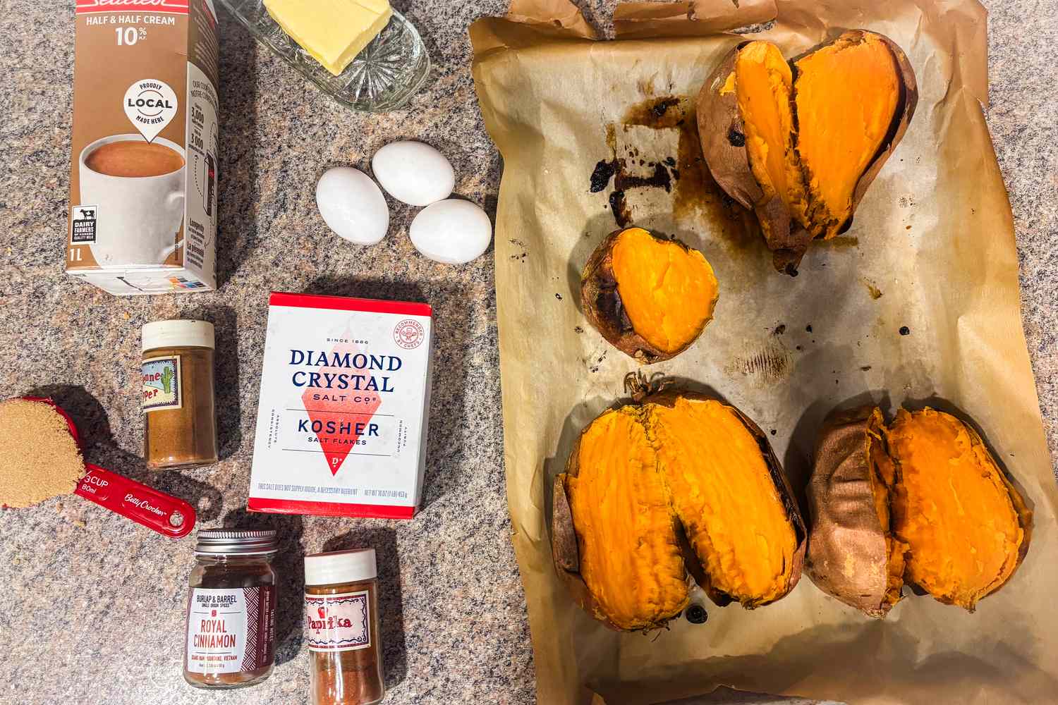 Ingredients for a casserole including sweet potatoes eggs spices and seasoning laid out on a countertop