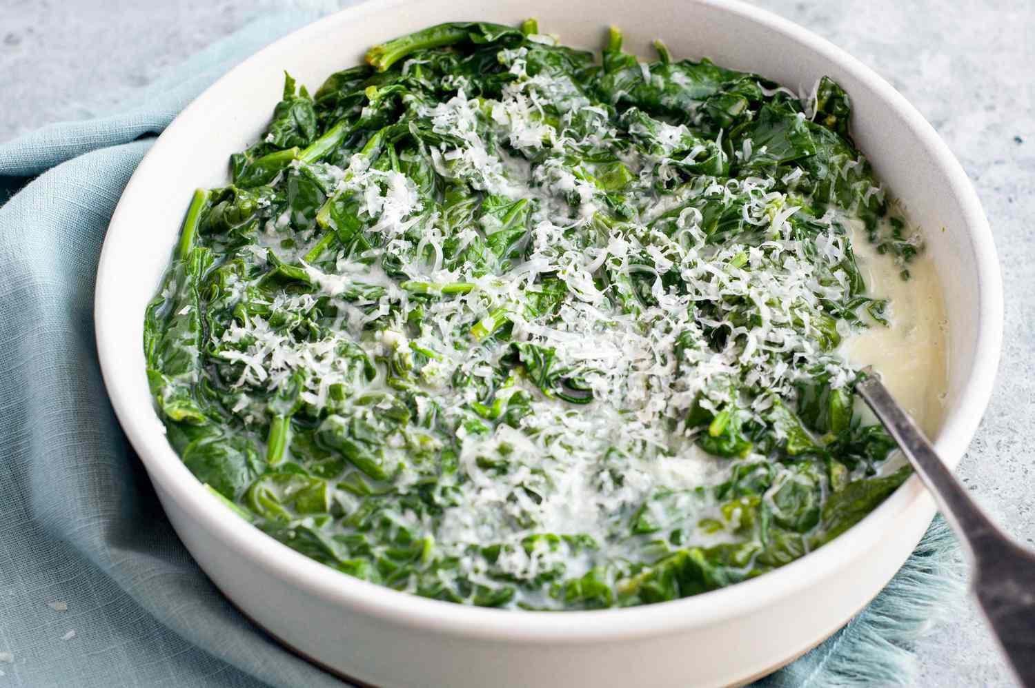 microwave creamed spinach in a white bowl