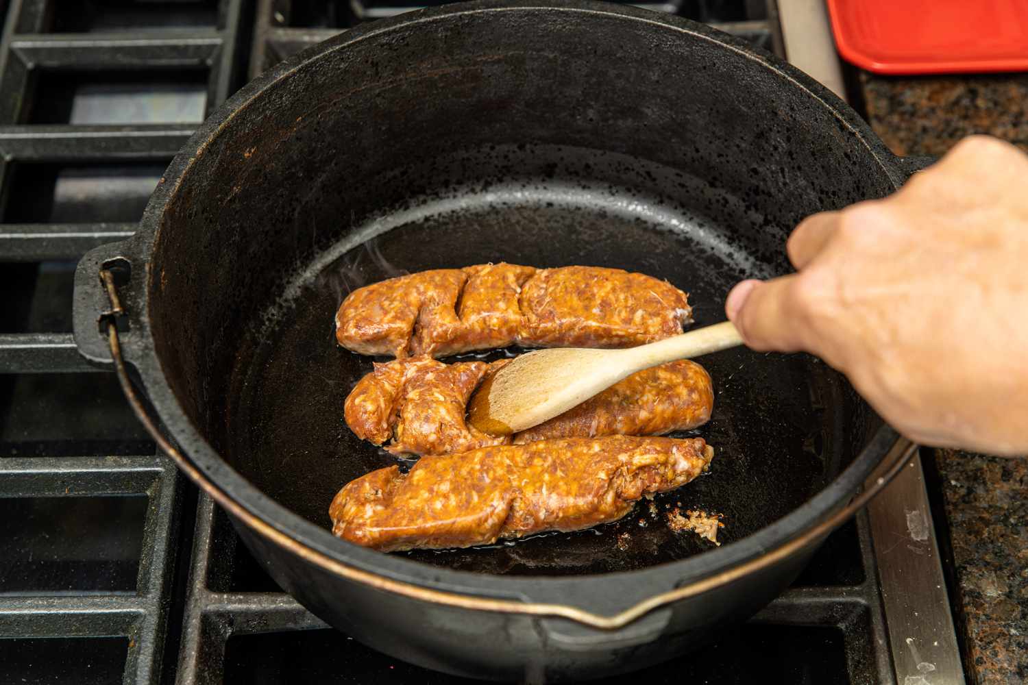 Sausage Smashed Using a Wooden Spoon in a Cast Iron Pot for Spaghetti Squash Soup with Italian Sausage