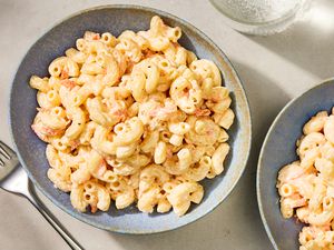 Hawaiian-style macaroni salad in a bowl, placed next to another bowl and a fork on a table